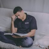 Adult care studiază seara la laptop, cu cărți și notițe, pregătindu-se pentru o nouă meserie