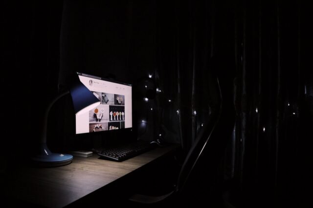 Birou cu un monitor așezat la distanță potrivită și o lampă care oferă lumină difuză pentru lucrul la calculator